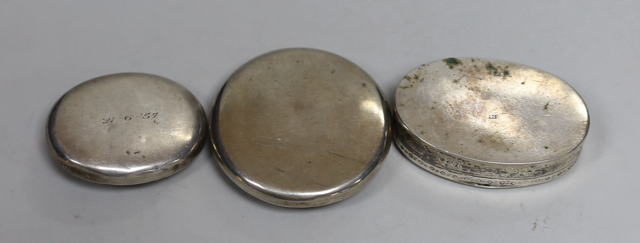 Two 19th century Dutch white metal snuff boxes, circular 56mm and oval and an 800 standard oval snuff box, decorated with horse and cart.